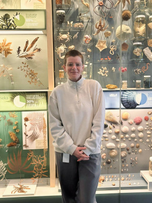 Elisha Minehan, Te Papa’s Senior Procurement Advisor stands in front of a case of specimens inside the national museum.