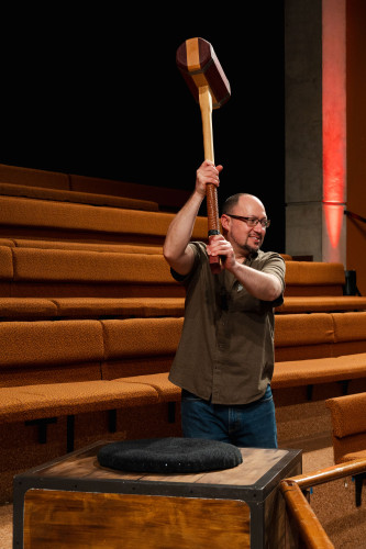 A man holding a hammer, ready to strike a box