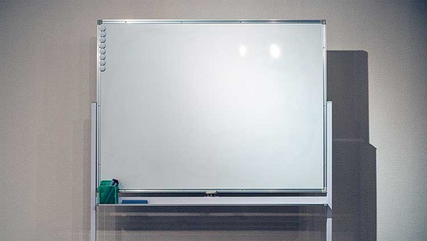 A freestanding whiteboard with a few magnets, markers, and a duster. The freestanding nature of the whiteboard means it's easier to move around the room as need be.